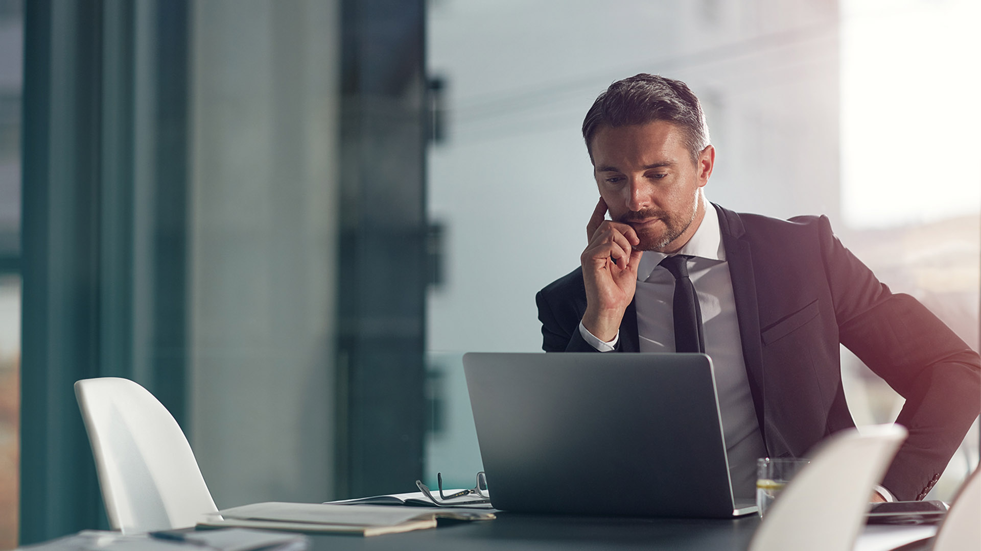 Laptop, thinking and office with a businessman working on research for future company growth. Computer, idea and innovation with a male employee or manager in a boardroom with review his strategy