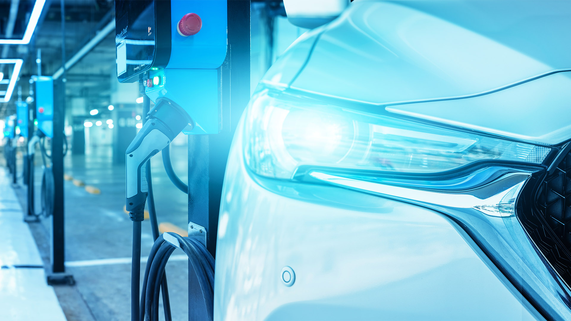 Electric vehicle charging station in indoor mall parking, EV battery charging point for sustainable transport, clean energy infrastructure for electric car, commercial charging facility in parking lot