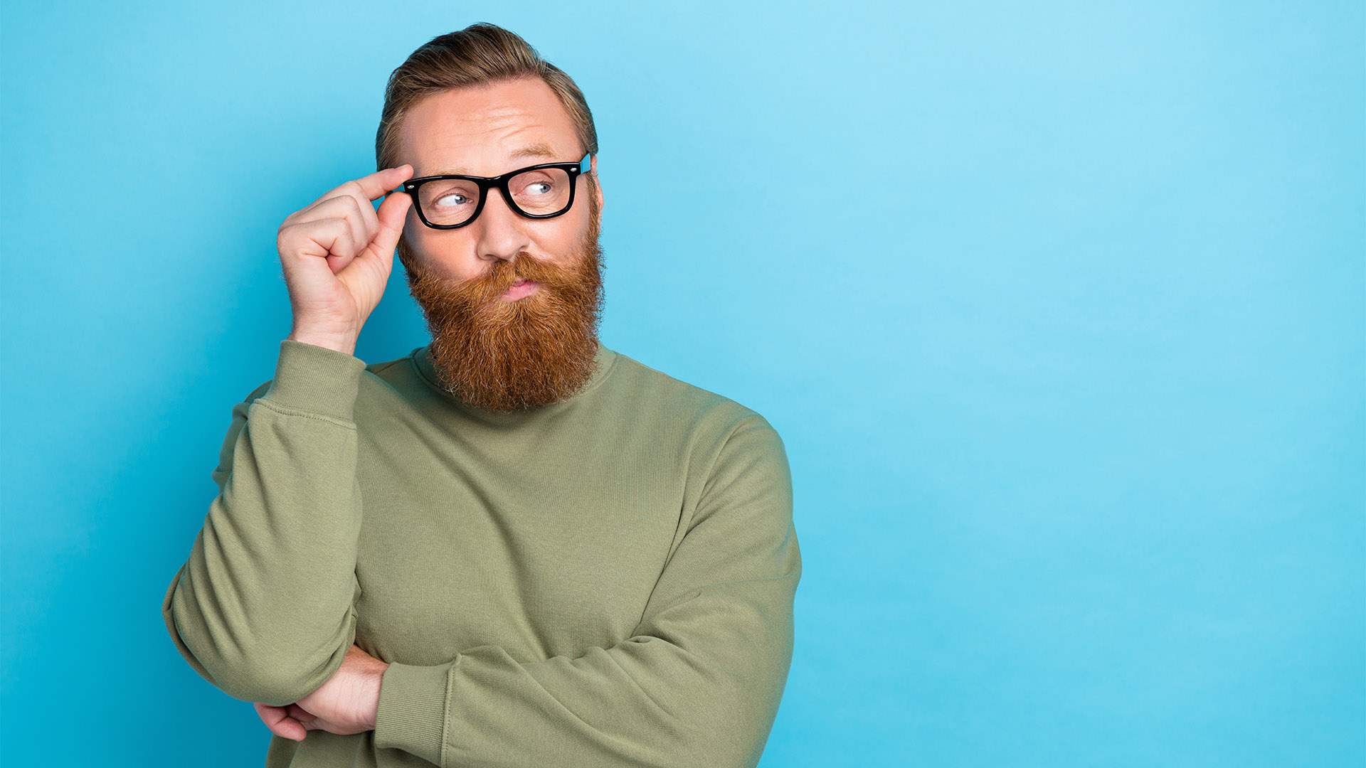 Photo portrait of attractive young guy touch eyewear look skeptical empty space wear khaki clothes isolated on cyan color background