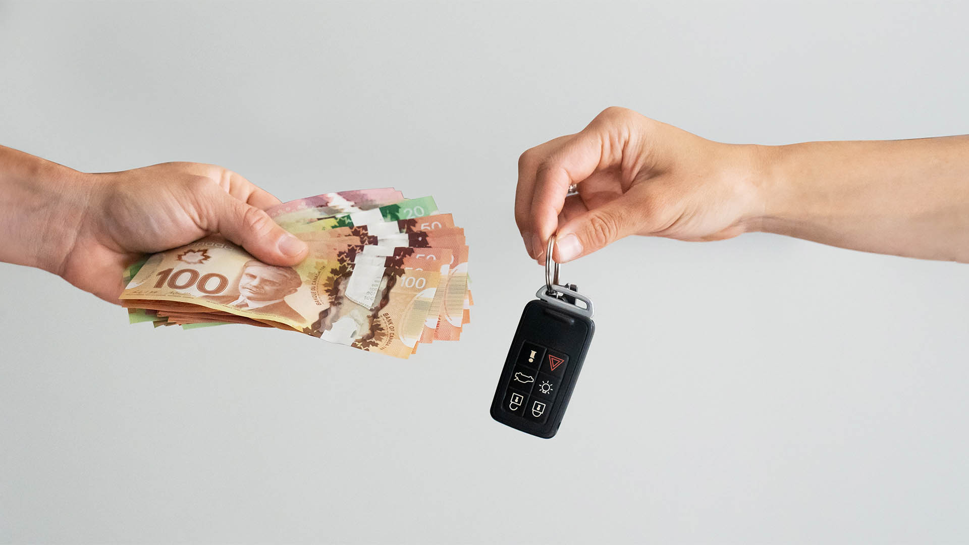 Hands holding car key and cash, Selling or Buying Car Concept