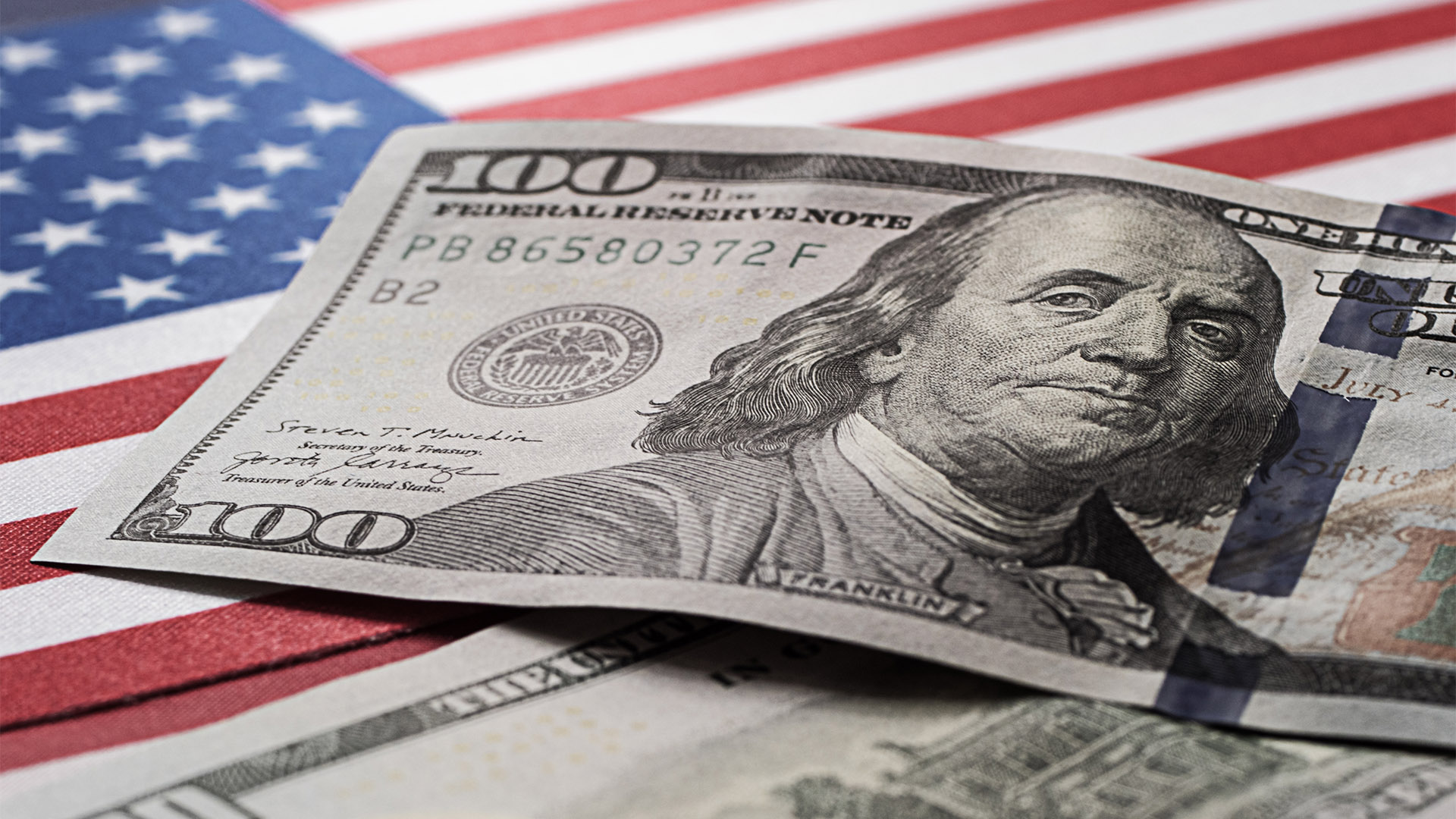 World currency 100 dollars on the background of the American flag. Business. Currency exchange. World crisis.