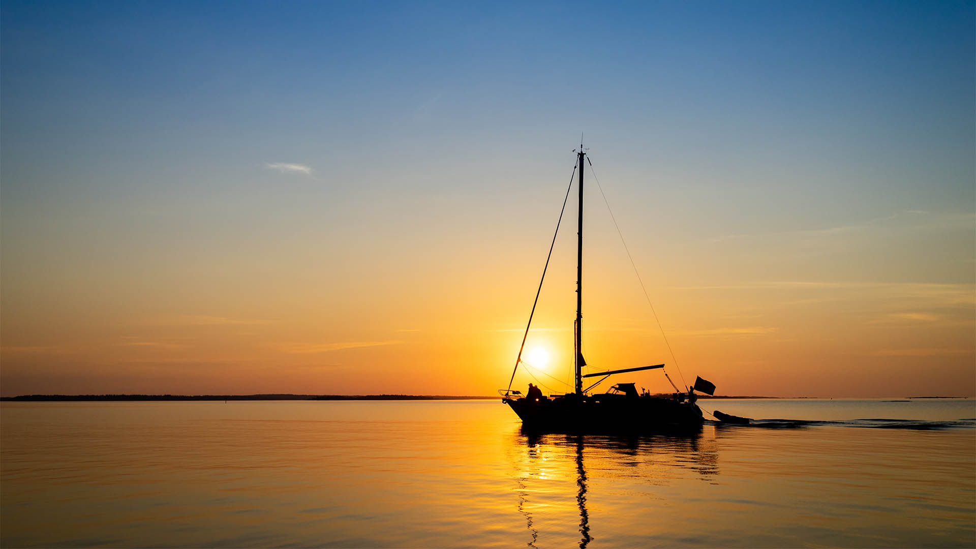 A sail boat on calm, smooth waters off the coast of the Aland islands.