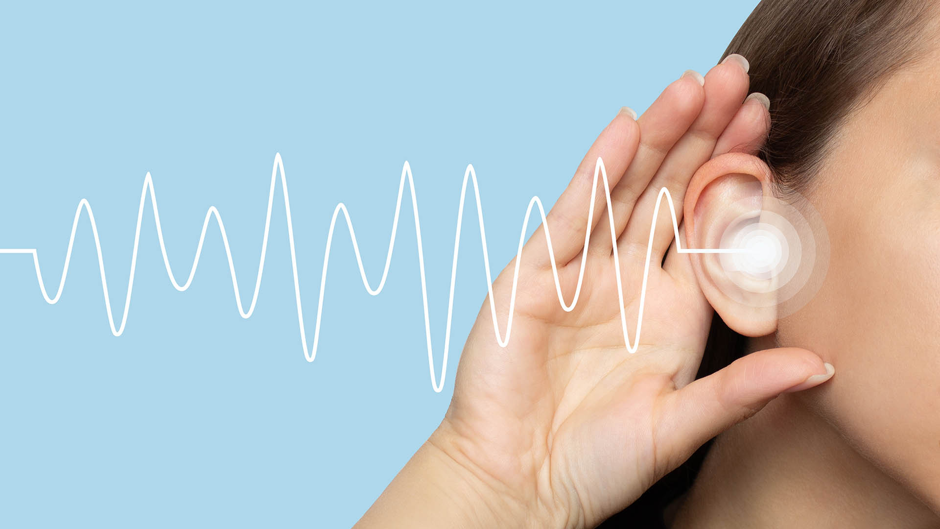 A woman puts her hand to her ear and listens, isolated on a blue background with sound waves. Hearing problems, ear diseases, noise. Concept of testing and hearing loss. Audiometry