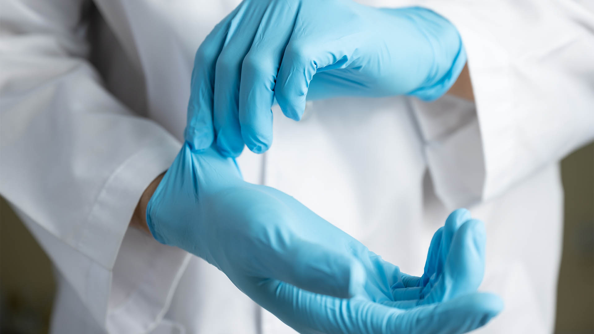 Doctor wearing blue nitrile gloves