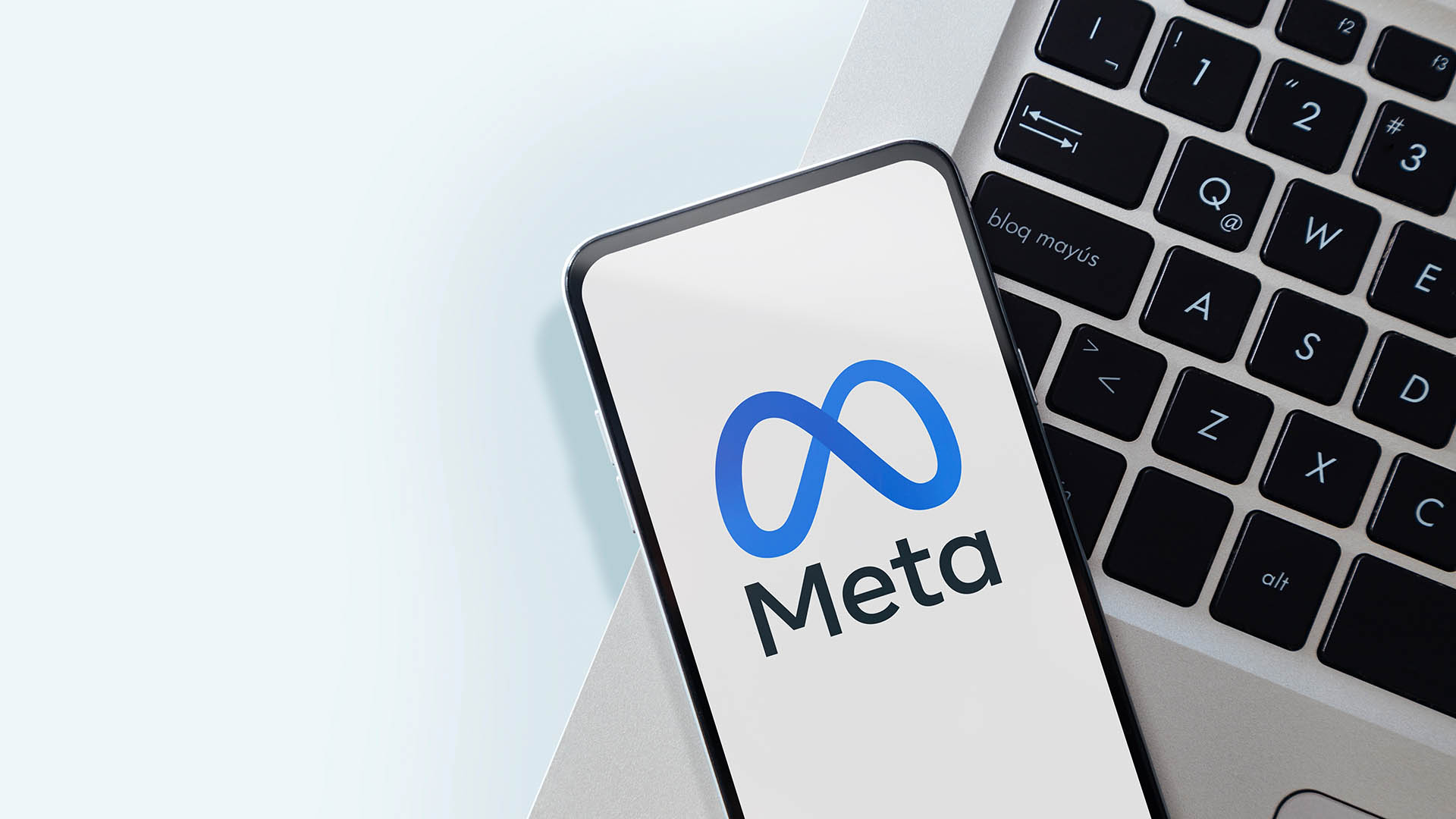 Rosario, Argentina - June 21, 2024: Meta logo on smartphone screen. Meta is the new name of the company that owns Facebook, WhatsApp and Instagram. Closeup of mobile phone over a laptop keyboard.