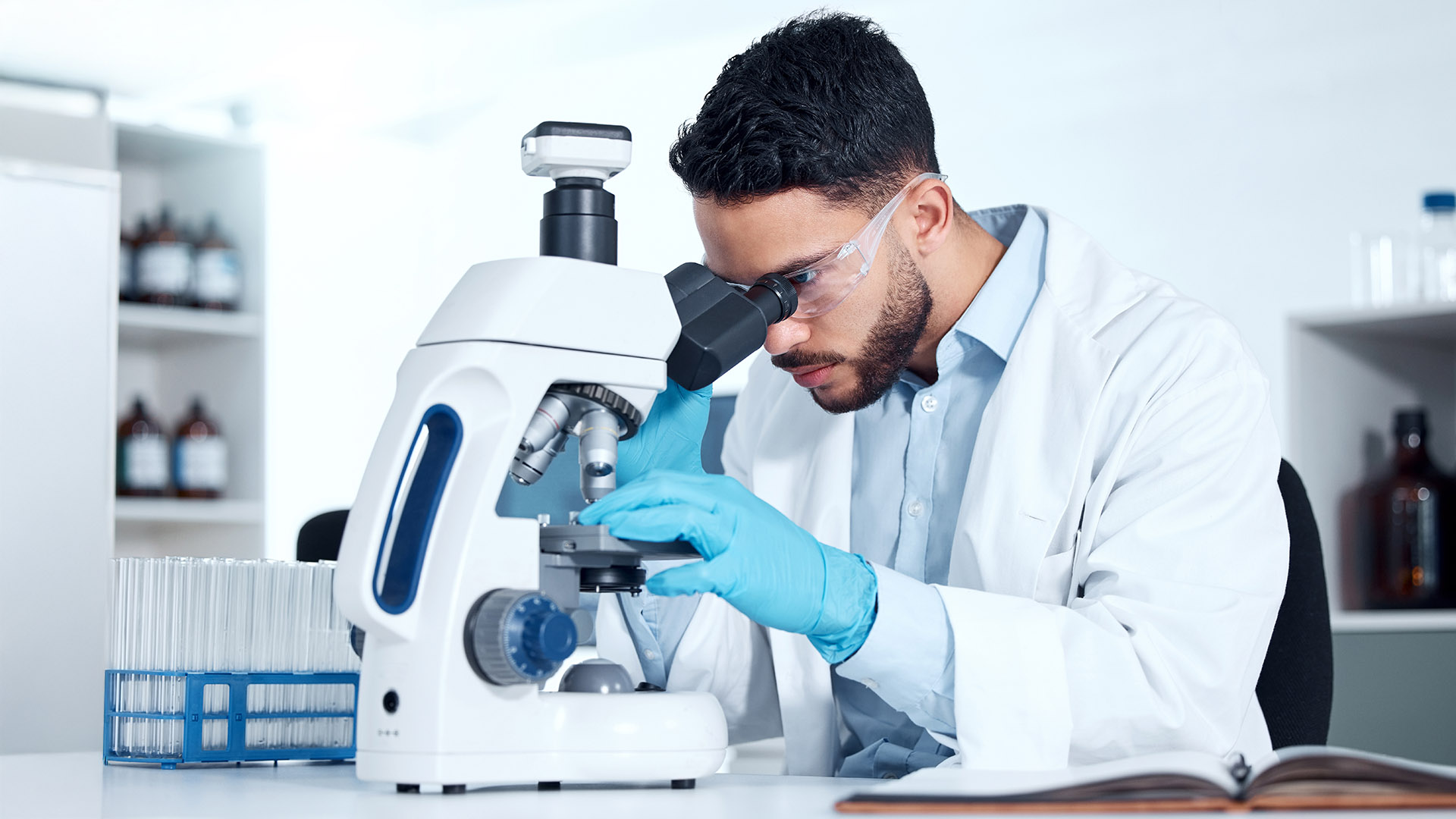 Man, microscope and analysis research in laboratory, biochemist and innovation healthcare study or virus sample. Investigation, cure development and examine or breakthrough, medical and equipment