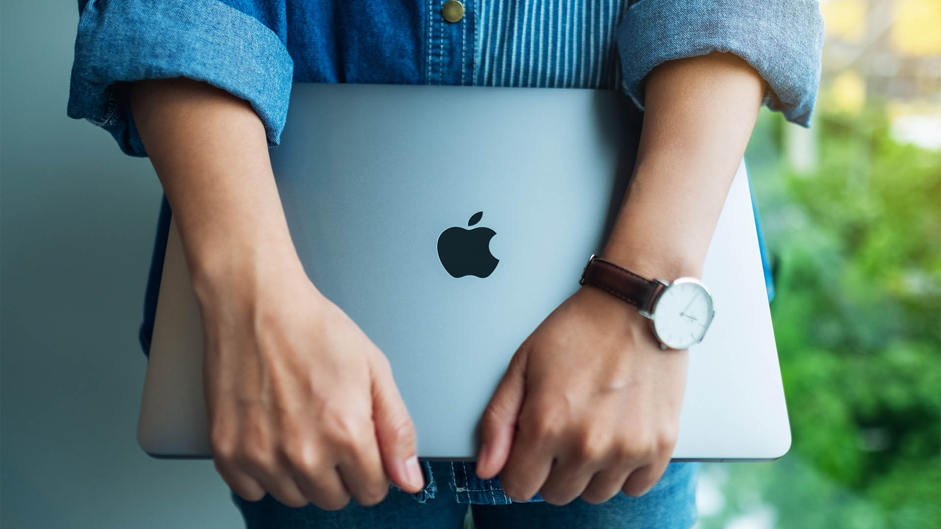 Aug 18th 2020 : A woman standing and holding an Apple MacBook Pro laptop computer , Chiang mai Thailand
