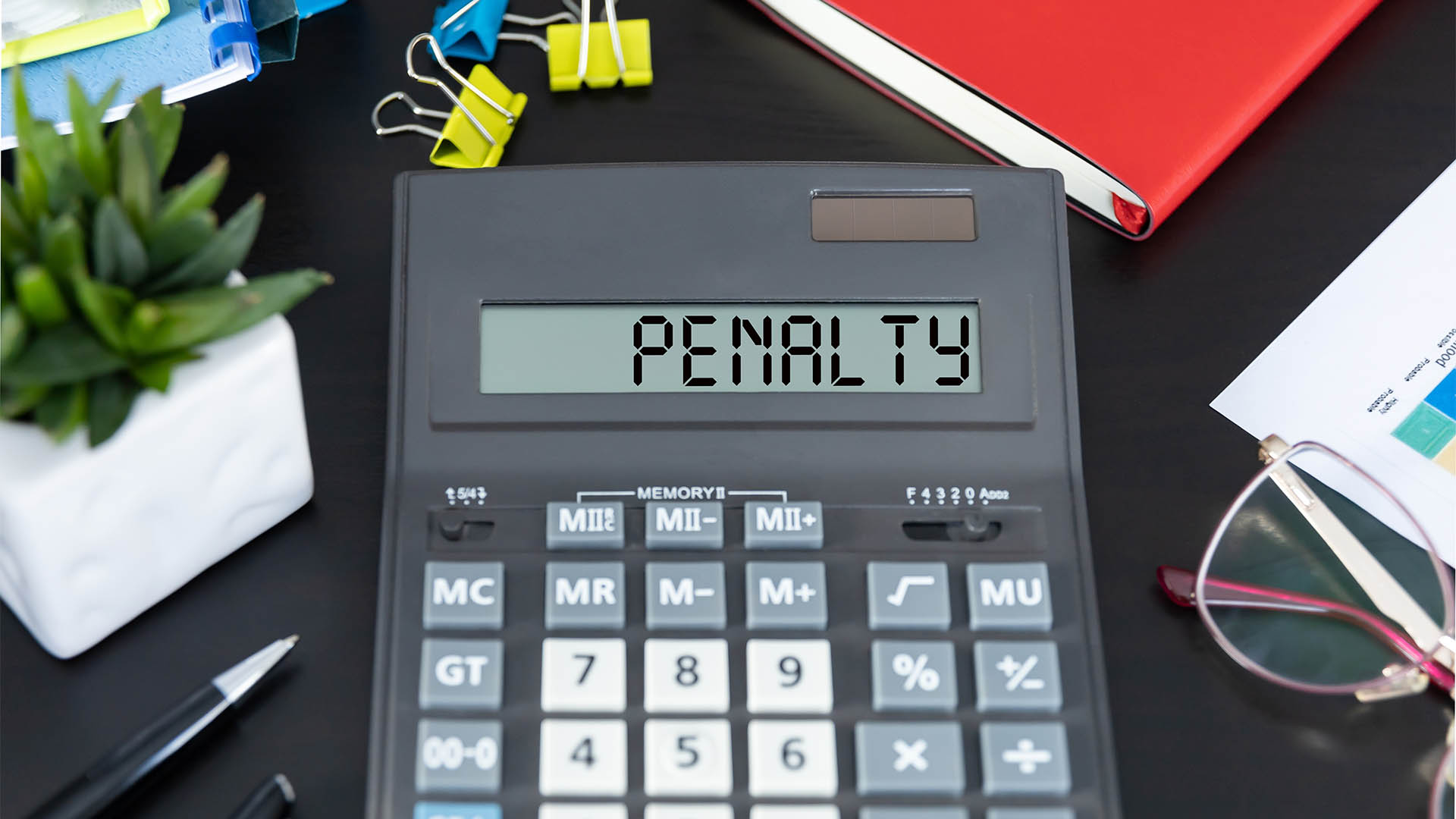 Word PENALTY on the display of a calculator on office desk