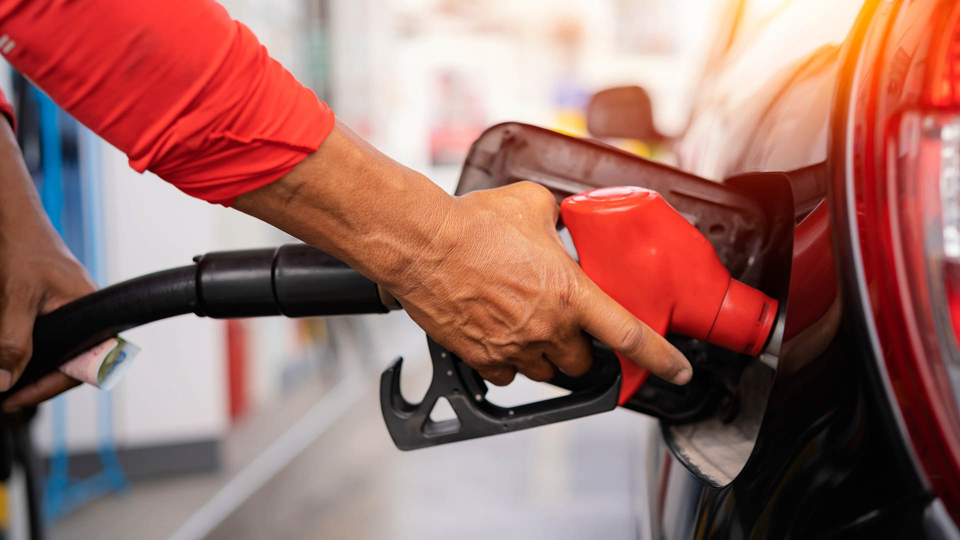 Refueling the car at a gas station fuel pump. Man driver hand refilling and pumping gasoline oil the car with fuel at he refuel station. Car refueling on petrol station. Fuel pump at station