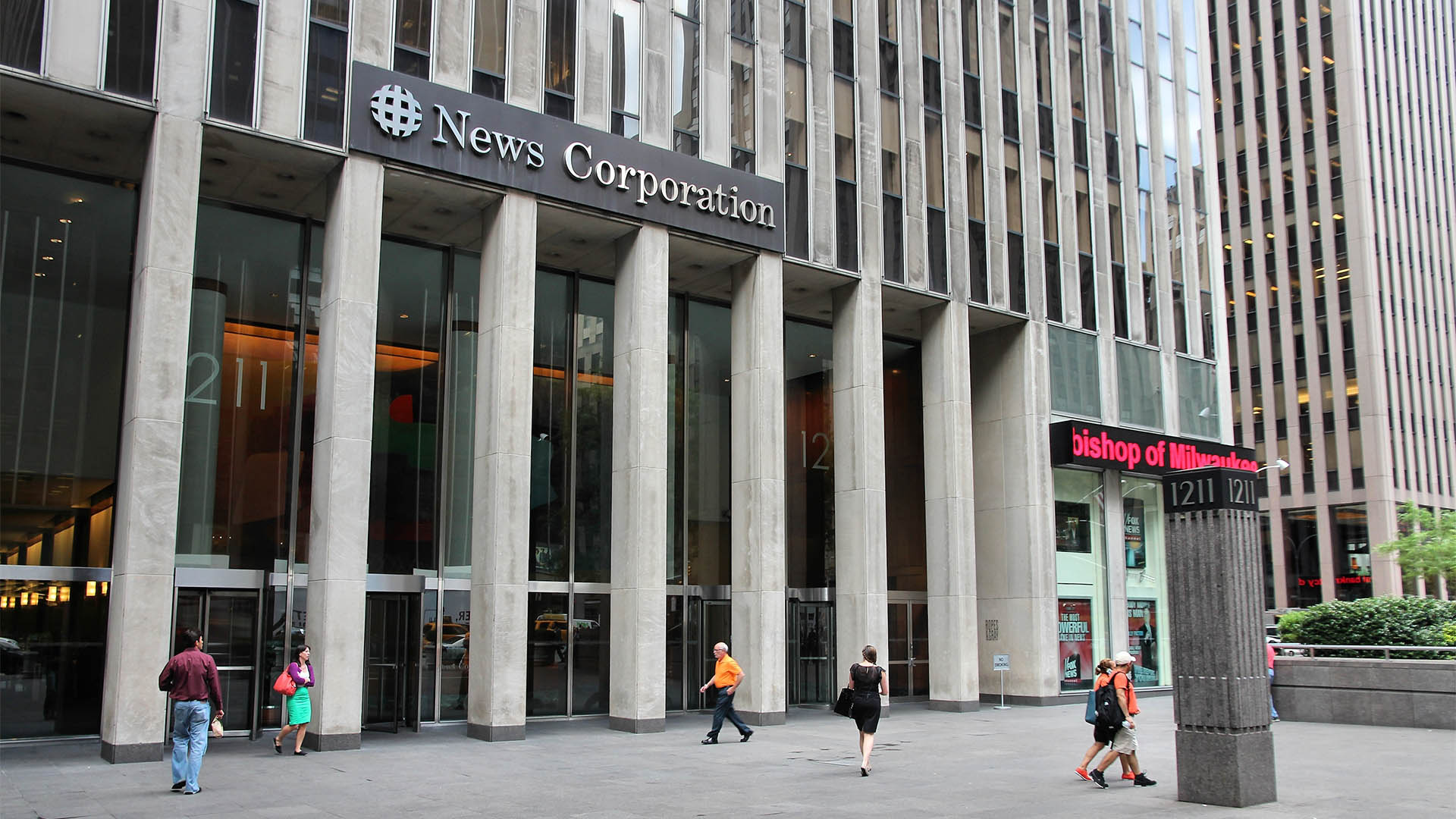 NEW YORK, USA - JULY 2, 2013: People walk past News Corporation at 6th Avenue in New York. Famous News Corporation was divided into News Corp and 21st Century Fox in 2013.