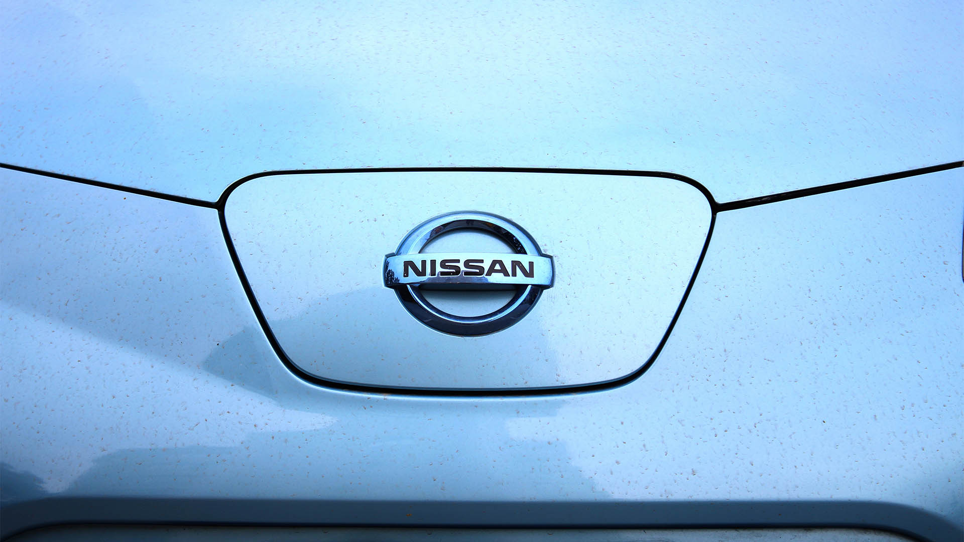 Vinnytsia, Ukraine; September 04, 2024. Blue Nissan Leaf front of the car. Electric car Nissan Leaf hood. Close up Nissan Leaf logo on charging hatch.