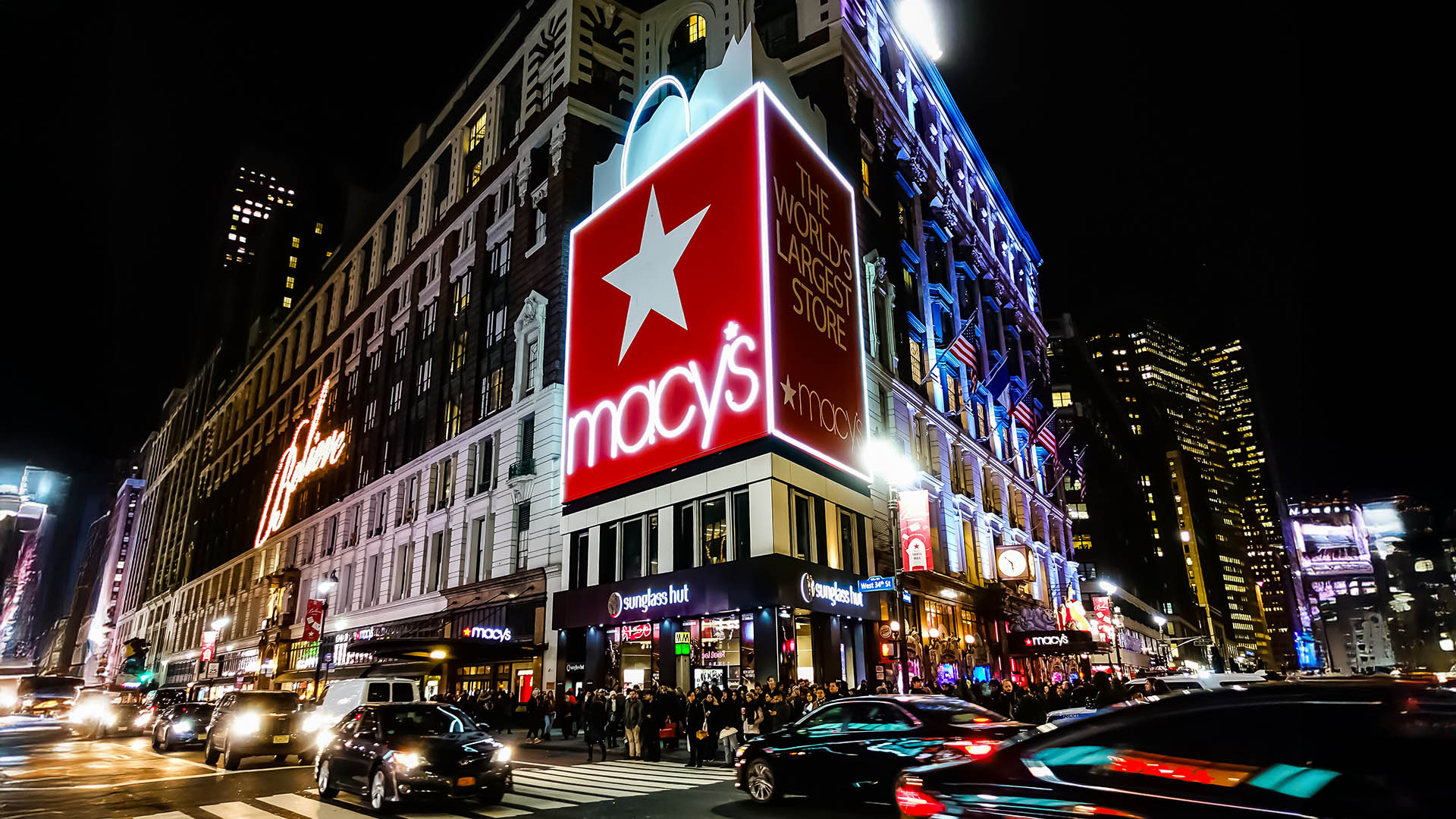 Macy's Herald Square Flagship Department Store in Midtown Manhattan with people crossing the street in front of it and yellow taxi's riding by. Manhattan, New York, USA - June 10, 2015
